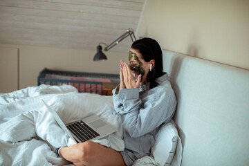 Young woman using her laptop in the bedroom