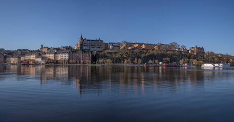 Morning view at the bay Riddarviksfjärden, old stone 1700s houses on the hill Mariabrget in the district Södermalm, a sunny early tranquil summer day in Stockholm