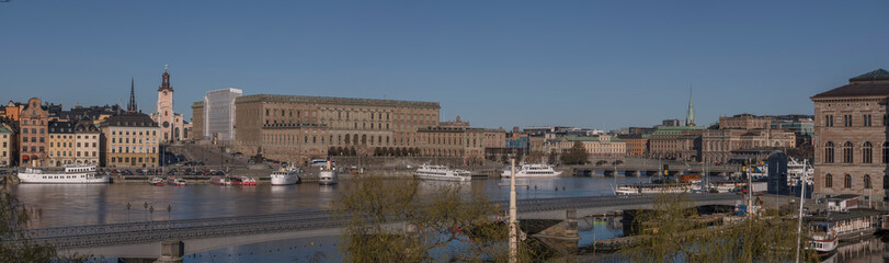 Fototapeta na wymiar View over the bay Strömmen, old town Gamla Stan, Government buildings museums and the Opera house, pier with moored commuting boats, a sunny early tranquil summer day in Stockholm