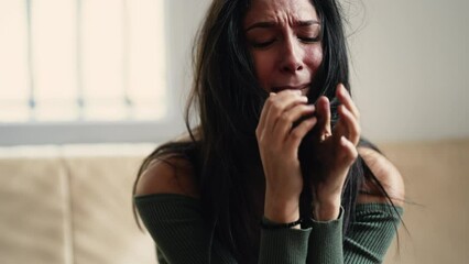 Distressed young woman overwhelmed with anxiety and sadness, feeling helpless and lost at home