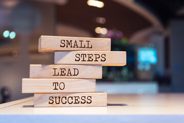 Wooden blocks with words 'Small steps lead to success'. Inspirational motivational quote.