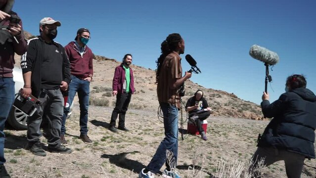 Funny boom operator enjoying himself, dancing on outdoor film set with crew