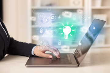 Hands working on laptop with digital icons