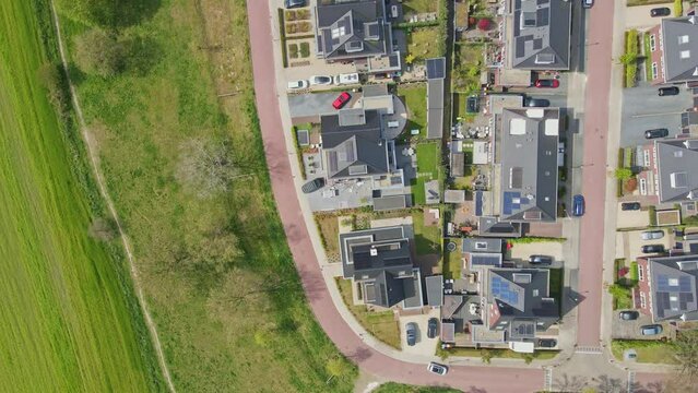 Top down aerial of a beautiful modern neighborhood with photovoltaic solar panels on rooftops