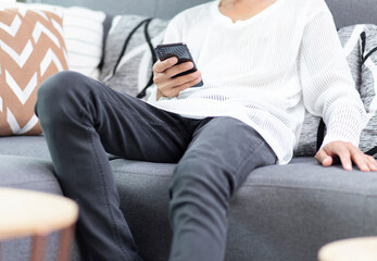lifestyle man  sitting on sofa at home and using smartphone application with watching live or online shopping