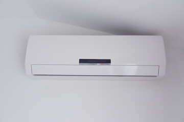 Air conditioner mounted on a white wall of apartment bedroom