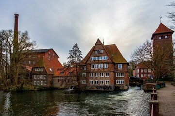 Ratsmuhle or old water mill and Wasserturm or water tower on Ilmenau river at morning in Luneburg. Germany