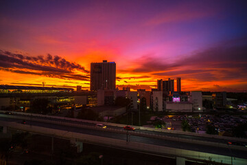 Fototapeta na wymiar Dusk's Radiance: Cityscape Silhouette against a Dramatic Pink and Orange Sky