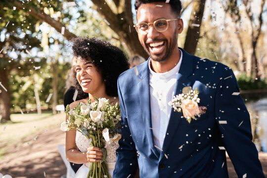 Wedding day, couple and confetti outdoor with happiness and smile from marriage event. Celebration, African people and bride walking with flower bouquet at love and trust commitment ceremony