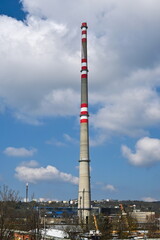 Fototapeta na wymiar Industrial area with tall chimney with cloudy sky in background