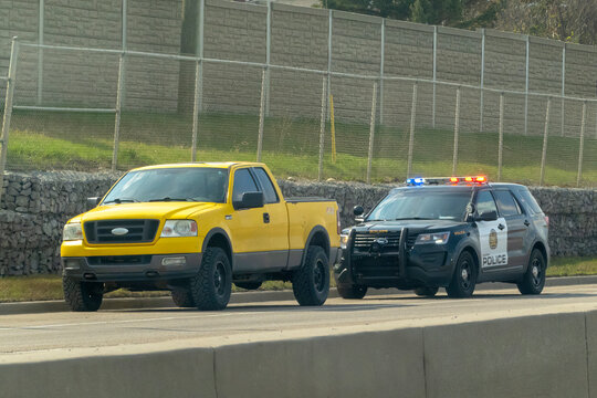 Calgary, Alberta, Canada. May 7, 2023. A Traffic Cop Police stoping a yellow truck. Concept: speeding tickets