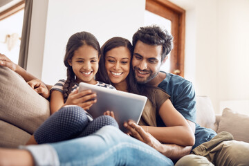 Happy family, people with tablet on sofa bonding and in living room in their home. Love or care, communication with technology and social media or movie streaming with mobile device on couch
