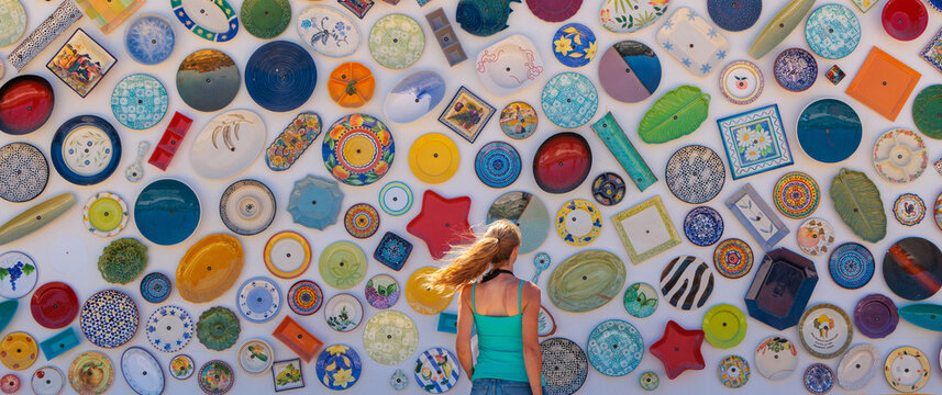 Decorative colorful porcelain on wall with woman tourist- Portugal