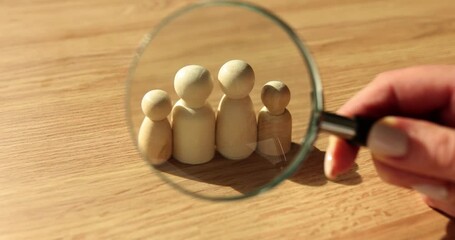 Wooden figurines of family and magnifying glass. Concept of classic traditional family