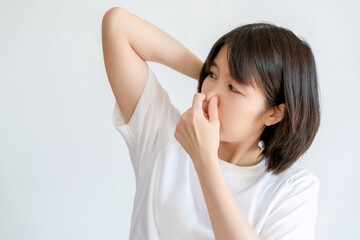 Woman covering her nose because of her own odor from her armpits. - obrazy, fototapety, plakaty