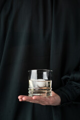 Hold handing a drink with a green background