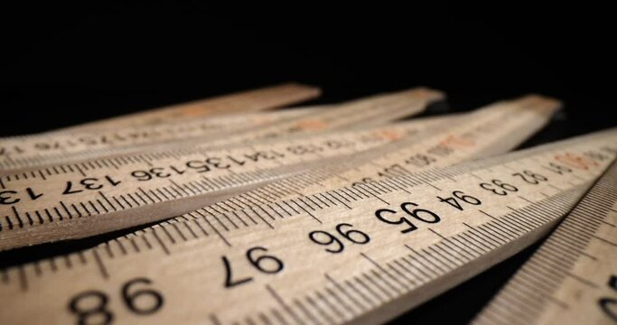 Construction folding wooden measuring tool. Folding carpenter's ruler on black background