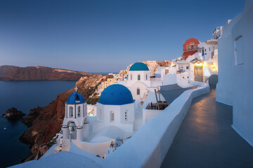 Naklejka premium Paradise found in Santorini! This iconic image showcases the island's stunning blue domes, white houses, rugged caldera, and endless sea.