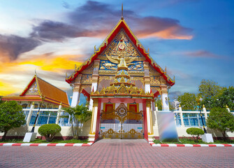 Beautiful Wat Buddhist temple in Phuket Karon Thailand. Decorated in beautiful ornate colours of Gold blue green red and White. Sunset Sunrise lovely sky and cloud colours