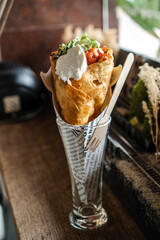 Mexican food tacos rolled up in a convenient cup for eating.