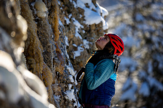 A woman with long hair looking at an ice climb