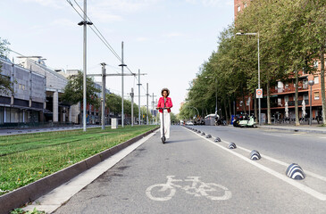 African-American woman driving electric scooter through the city