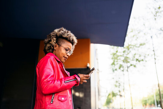 African American woman using the mobile phone in the street