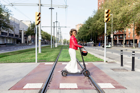 African-American woman driving electric scooter through the city