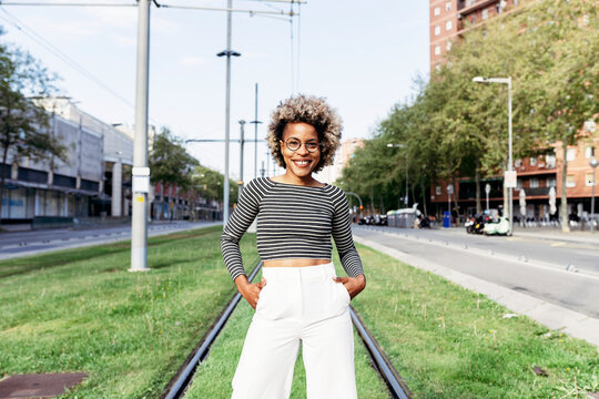 Portrait of Afro-American woman posing in the street with white pants