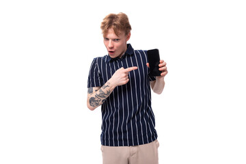 handsome young white-haired man in a blue polo with tattoos shows ads on the phone