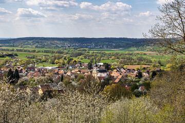 Church of Saint Kilian at Pretzfeld, Germany in Franconian Switzerland through cherry trees in...