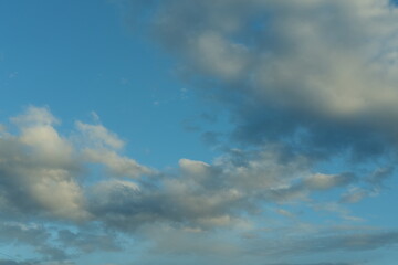 Blue sky background with white fluffy cumulus clouds. Panorama of white fluffy clouds in the blue sky