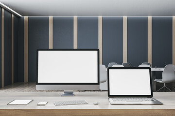 Contemporary designer office desktop with empty white mock up computer screens, supplies and blurry interior background. 3D Rendering.