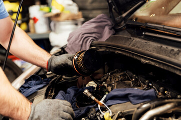 close-up of the hands of a car mechanic changing a dirty fuel filter. filter replacement in the car. car repair service. used fuel filter © Vadym
