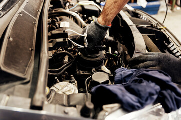 car repair in the garage. the specialist looks under the hood of the car and checks the motor.mechanic in the process. car service concept. auto service.