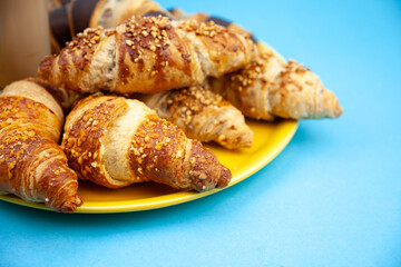 Chocolate croissants or croissant with nut crumbs on a plate. Delicious breakfast on the table. Tasty sweet baking dessert for coffee. Food background. Fresh buttery croissants rolls