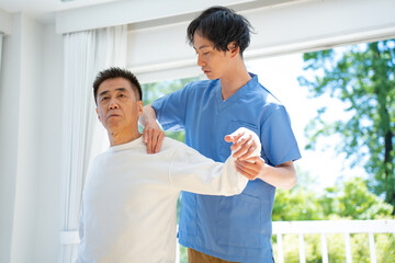 マッサージする男性と施術を受ける日本人シニア男性