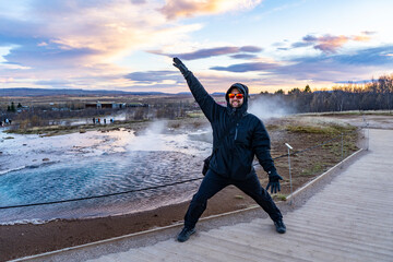 happy man poses and smiles at geysir geyser strokkur hot springs