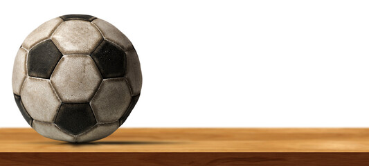 Closeup of an old leather soccer ball on a wooden table isolated on white or transparent background...