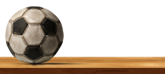 Closeup of an old leather soccer ball on a wooden table isolated on white or transparent background with copy space. Photography, png.