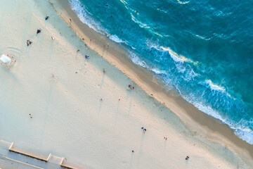Aerial top down view of beach and clear blue water. Ocean waves on the beach as a background. Beautiful natural summer vacation holidays background. City Beach, Western Australia. Coastal seascapes