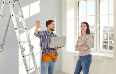 Young married couple is planning an apartment renovation and design project standing in empty room...