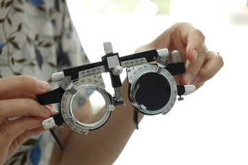 close up of hand holding trial frame glasses 