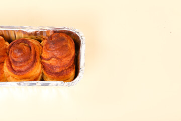 isolated cinnamon rolls in aluminum foil packaging
