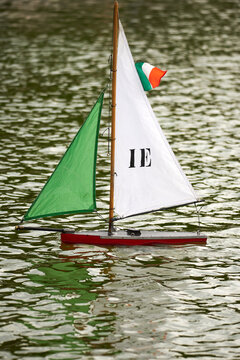 Vertical shot of a colorful remote-controlled boat in the water in Luxembourg Garden