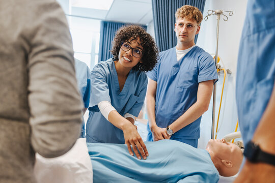 Students wearing scrubs receive medical training in a clinical simulation centre