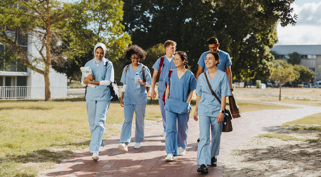 Medical students wearing scrubs walking together after class