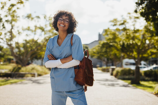 Excited to become a doctor: Female medical student wearing scrubs on campus