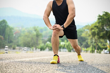 Cropped image, A sporty Asian man in sportswear stretching his legs, doing lunges