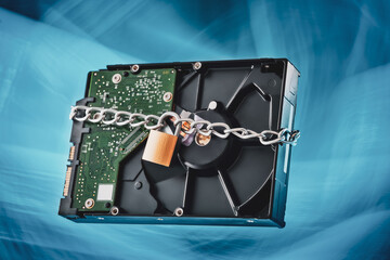 The hard drive is chained and locked. Abstract blue background.